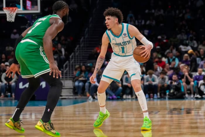 LaMelo ball dribbles as Jaylen Brown defends him